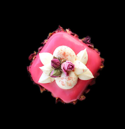Pink rose bouquet dessert with cream and dried edible flowers isolated on black backgroundの写真素材