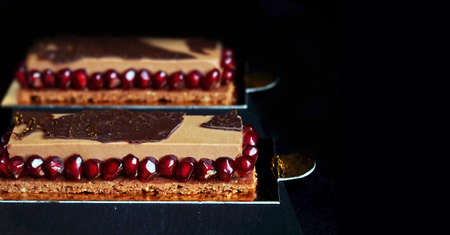 Chocolate mousse dessert with pomegranate seeds on black background
