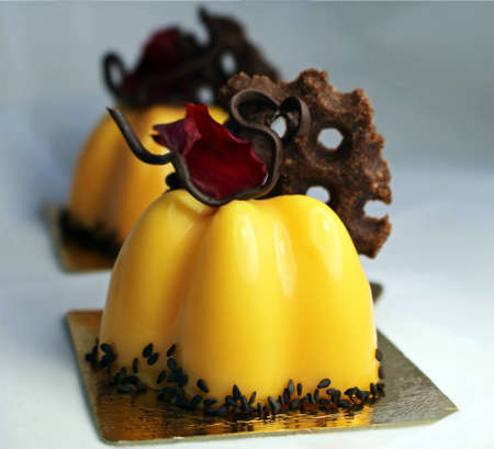 Orange cake with rose petal and chocolate decor and black sesame seedsの写真素材