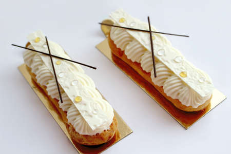 White vanilla eclairs with chocolate decorationsの写真素材