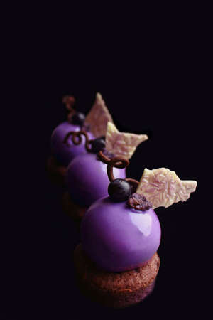 Purple grapes desserts with white chocolate decor on black backgroundの写真素材