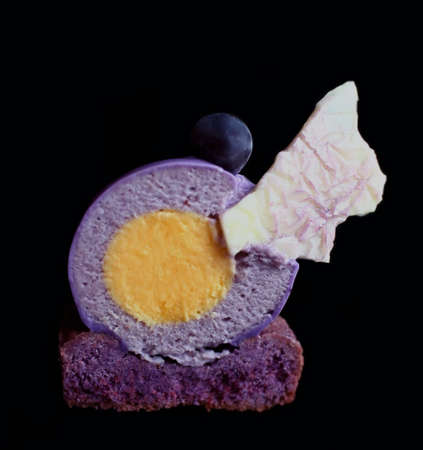 Purple grapes round dessert section with orange insertion and white chocolate decorationの写真素材