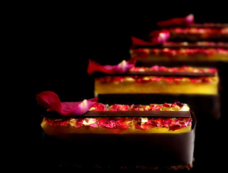 Lemon and chocolate dessert with rose petals on black backgroundの写真素材