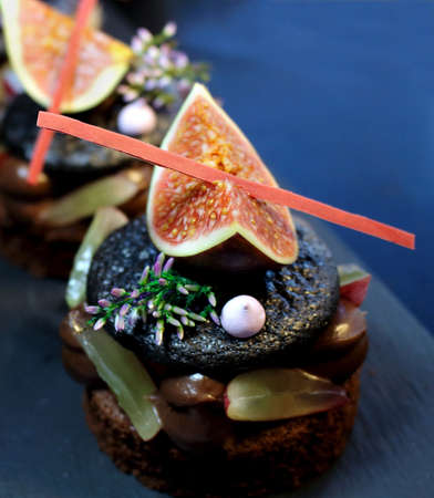 Fig and grapes macaron dessert on blue backgroundの写真素材