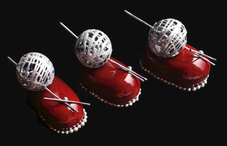 Three red chocolate berry desserts with silver wool ball decoration and sprinklesの写真素材