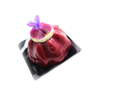 Red fruit dessert with edible purple pea flower isolated on white backgroundの写真素材