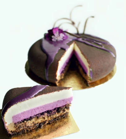 Chocolate textured spring flower cake with purple mirror glaze cover and chocolate spiral decoration, slicedの写真素材