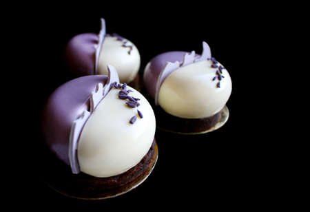 Purple and white round mousse lavender desserts isolated on black backgroundの写真素材