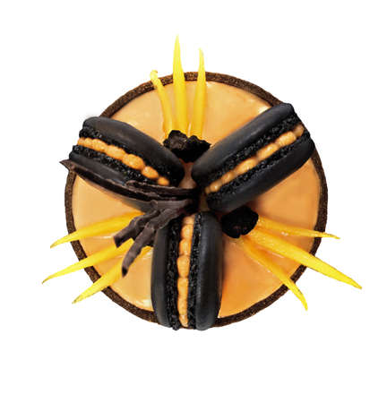 Orange chocolate tart with black french macarons and persimmon on white backgroundの写真素材