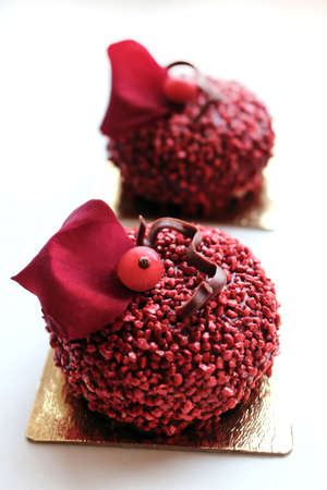 Red textured desserts with red currant berries and edible red rose petalの写真素材