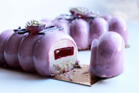 Purple shiny glazed grape desserts with fresh grapes, spring flowers and chocolate decorations, slicedの写真素材