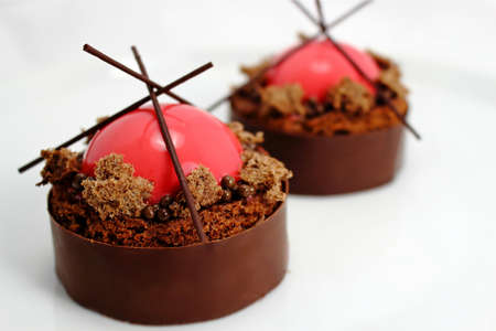 Strawberry and brownie dessert with dark chocolate jelly caviar on chocolate borderの写真素材