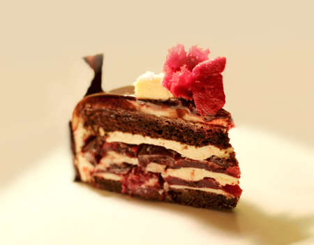 Traditional Black Forest layered chocolate cake slice with red decorations and cherries
