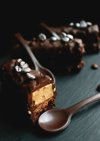 Sliced coffee dessert with silver coffee beans and chocolate spoonの写真素材