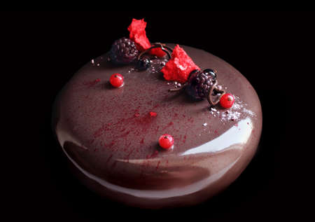 Round chocolate cake with berries on black backgroundの写真素材