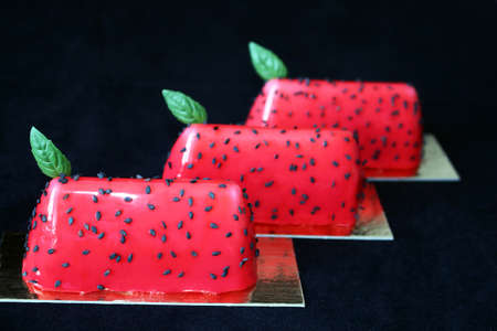 Red watermelon glazed desserts with black sesame seeds and basil leavesの写真素材