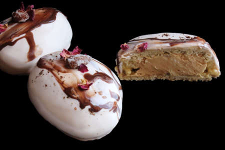 Sliced coffee and chocolate stone desserts with almonds and rose petals on black backgroundの写真素材