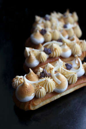 Lemon pie eclairs with purple crumble, citrus ganache and meringueの写真素材
