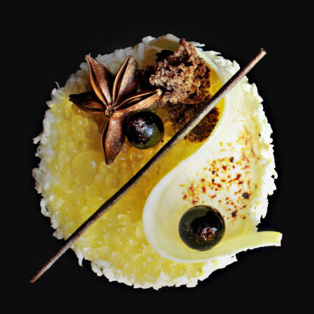 Underwater yellow lemon jelly caviar and white melon mousse dessert with coconut, honey, white chocolate and star anise, top viewの写真素材