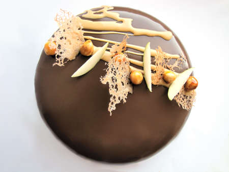 Apple and caramel nutty chocolate cake on white backgroundの写真素材