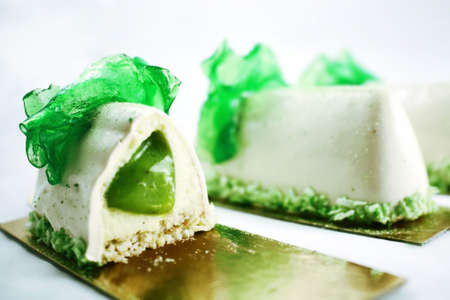 Sliced coconut water mousse dessert with green grapes and shiny green caramel decorationの写真素材