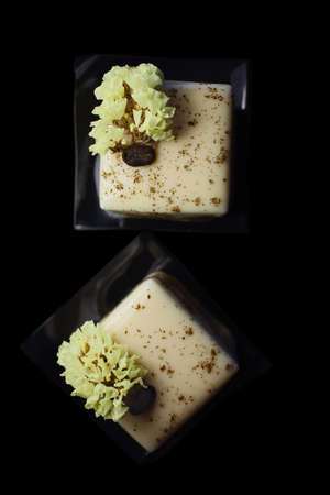 Coffee cube desserts with coffee bean and spring flower flat lay isolated on black backgroundの写真素材