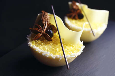 Yellow half sphere lemon jelly caviar and white melon mousse dessert with coconut, honey, white chocolate and star aniseの写真素材
