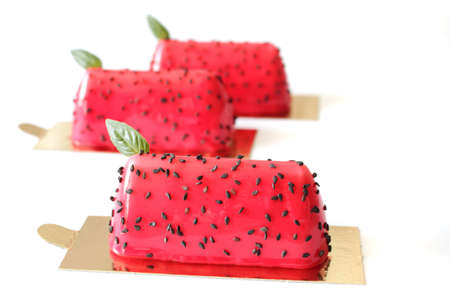 Red watermelon glazed desserts with black sesame seeds and basil leavesの写真素材