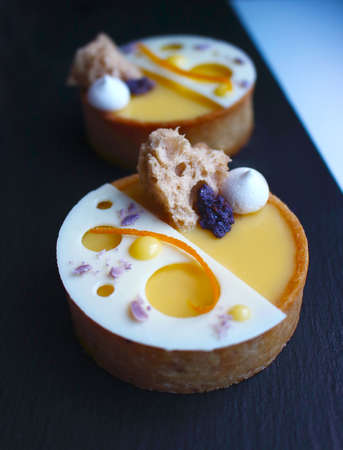 Orange tartelettes with meringue, microwave sponge and white chocolate decorationの写真素材