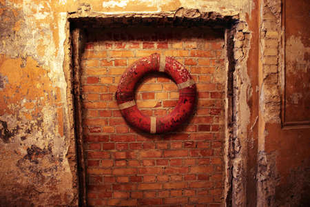 Red brick wall with red lifebuoyの写真素材