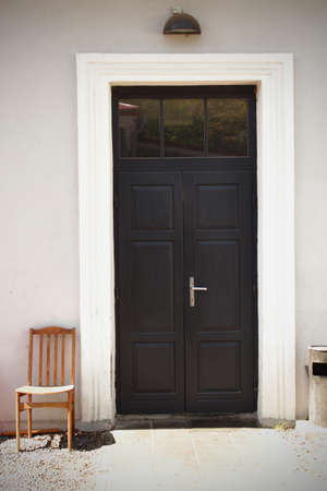 Old wooden chair in a yard near the entrance door