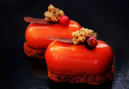 Brown glazed desserts with cranberries and chocolate on brownie base