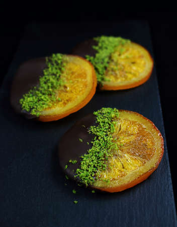 Caramelized oranges in chocolate and green pistachiosの写真素材