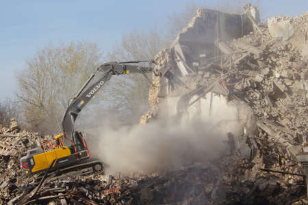 Demolished old soviet union building remains with orange bulldozer