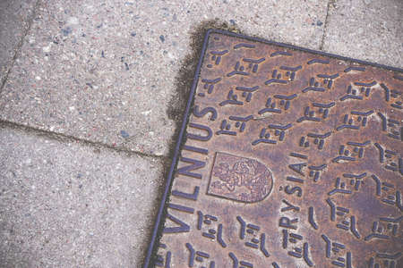 Vilnius city pavement textured iron hatch with emblem on concrete tilesの写真素材