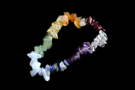 Colorful crystal chakras bracelet isolated on black backgroundの写真素材