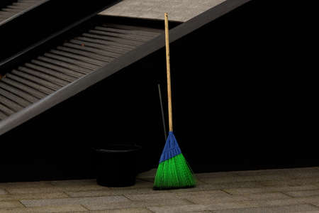 Bright blue and green synthetic street mop with black bucket and a scoop on city squareの写真素材