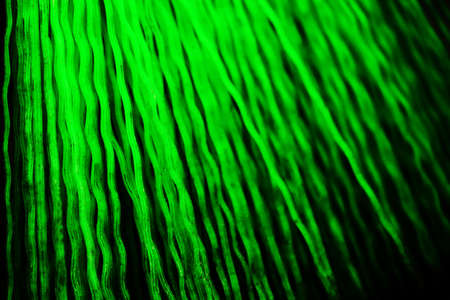 Green plastic abstract wavy lines with dark shadows misty backgroundの写真素材