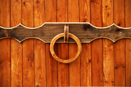 Bright wooden entrance gate with round knocker handle