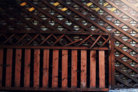 Wooden diagonal trellis and fence with sunlight in one cornner