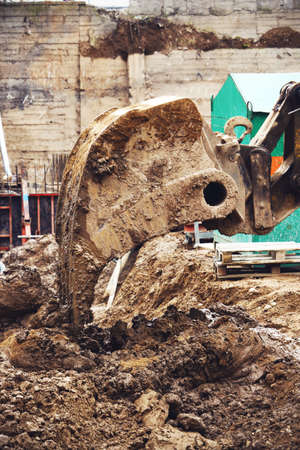 Excavator at work digging sand on construction site