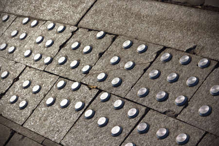 Pavement border grey texture with metal circles for blind