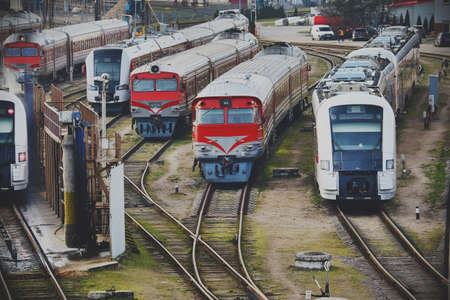 Various red and blue trains standing diagonally on railsの写真素材