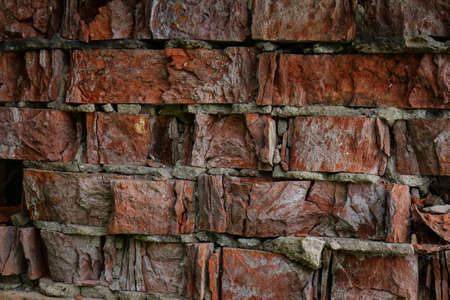 Red old crumbling weathered brick wall textured backgroundの写真素材