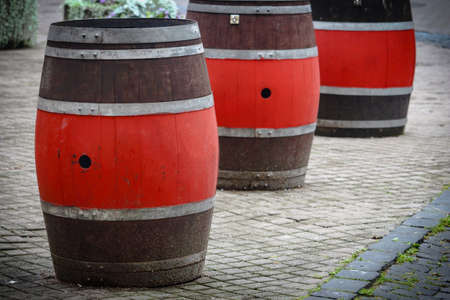 Brown and red big barrels standing on street pavement as street cafe tablesの写真素材