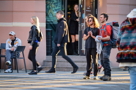 Vilnius, Lithuania - June 06 2022: Two male friends standing together in the street listening to...