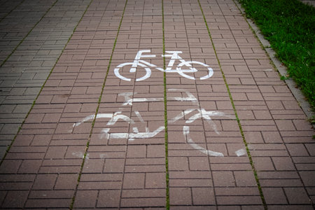 White painted roadsign of two bicycles on grey road old and newの写真素材