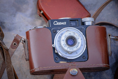 Daugavpils, Latvia - 16 09 2023: Old Smena black camera in old brown leather case at flea marketのeditorial素材