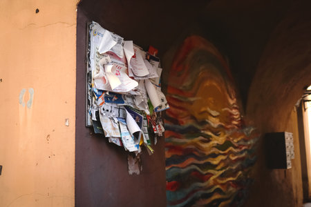 Urban life photo of a street bulletin board with many leaflets with information and news hanging in a yard of old townの写真素材