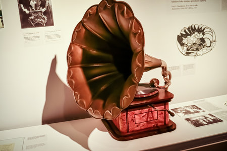 Vintage gramophone of bronze and wood with deep shadows side view